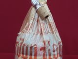 a bag of bread wrapped in plastic on a red surface