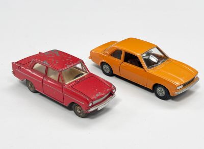 deux voitures jouets assises l'une à côté de l'autre sur une surface blanche