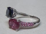 a close up of a ring with a pink sapphire and a black diamond