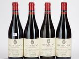 trois bouteilles de vin rouge sont alignées sur une surface blanche