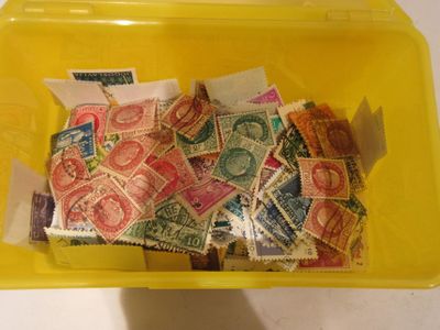 un récipient jaune rempli de timbres-poste posé sur une table