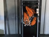 un rack contenant tout un tas de câbles, dans une pièce