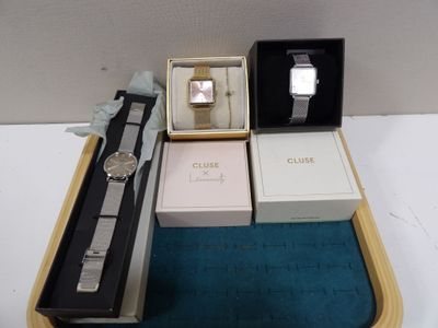 trois montres et une montre dans une boîte posée sur une table