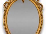 un miroir ovale doré orné d'un motif décoratif sur le pourtour