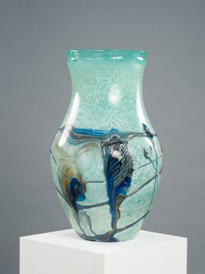 un vase en verre posé sur un socle blanc