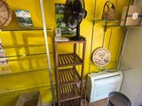 un mur jaune avec des étagères et un ventilateur dans un coin