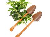 two shovels sitting next to a potted plant on a white surface