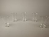quatre vases en verre transparent sont alignés sur une surface blanche