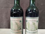 two bottles of wine sitting on top of a table next to each other