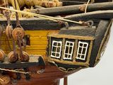 a wooden model of a ship on display on a table