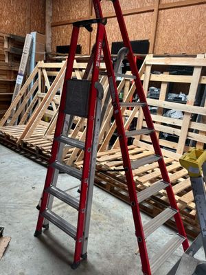 une échelle posée au milieu d'une pile de palettes