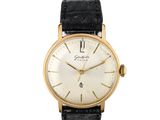 gros plan d'une montre-bracelet en or sur fond blanc