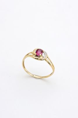 a gold ring with a ruby stone and diamonds