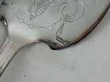 a silver spoon with a design on it sitting on a table