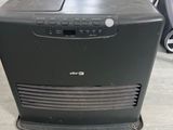 un purificateur d'air posé sur un parquet, à côté d'une chaise
