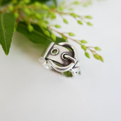 a close up of a silver ring with a face on it