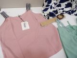 a pink tank top and green pants on a white table