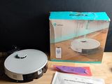 a robot vacuum sitting on a wooden table next to a box