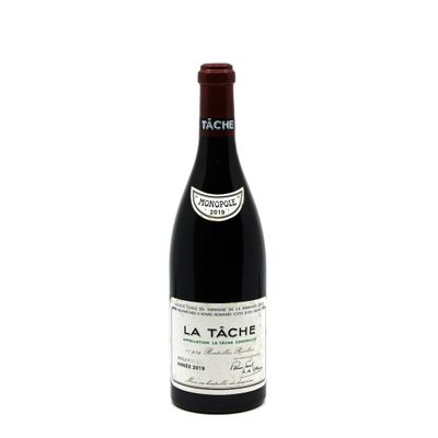 a bottle of red wine sitting on top of a white table