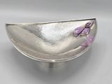 assiette en argent ornée d'une fleur violette sur un fond gris