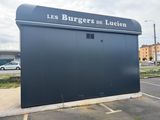 a sign that says les burgers de lugien on the side of a building