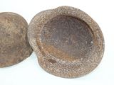 a stone bowl and a stone ball on a white surface