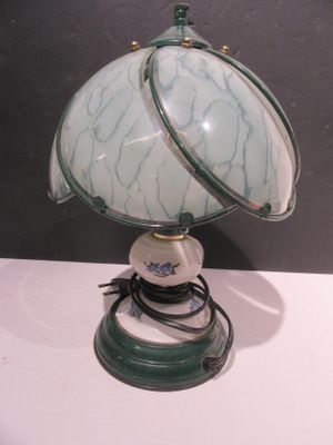 a green and white lamp that is on a white table