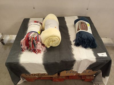 deux couvertures posées sur une table, sur laquelle est posée une pancarte