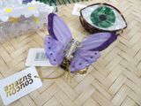 a purple butterfly sitting on top of a table next to other items