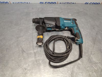 a close up of a corded drill on a metal surface