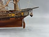 ship model made of wood with sails and a wooden stand