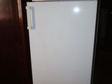 a white refrigerator in the corner of a room