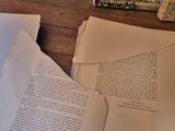 a pile of papers sitting on top of a wooden table