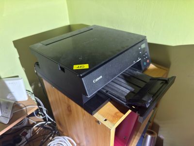 a black printer sitting on top of a wooden shelf