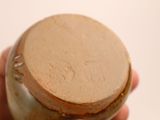 a person holding a jar with a brown lid