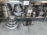 many pots and pans on the shelf in the kitchen