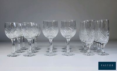 six verres à vin en cristal sont alignés sur une surface blanche