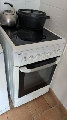 un four de cuisine blanc posé à côté d'un lave-linge et d'un sèche-linge