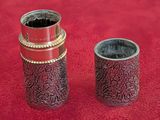 two vases that are sitting on a red surface