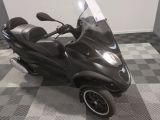 un scooter garé sur un sol à damier