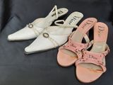 deux paires de chaussures blanches et roses posées sur une surface noire
