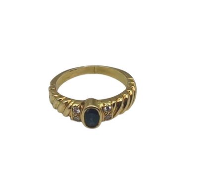 a close up of a gold ring with a blue stone