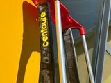 a pair of skis and a pair of ski poles leaning against a yellow wall