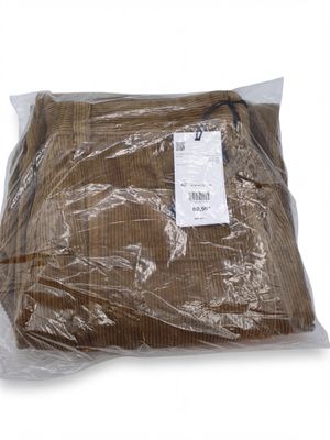 un sac en tissu marron posé sur une surface blanche