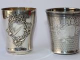 deux tasses en argent posées l'une à côté de l'autre sur une table