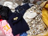 a pile of clothes sitting on top of a bed