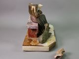 a figurine of a woman sitting on top of a book