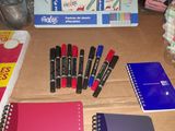 a lot of pens and notebooks on the table