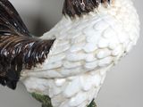 a white and black rooster figurine sitting on a table