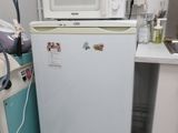un petit réfrigérateur blanc dans le coin d'une cuisine
